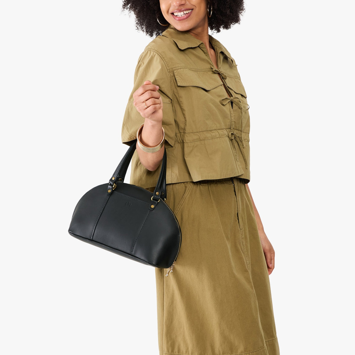 Black*Small | Model holding a half circle crossbody bag with handles and removable crossbody strap 
