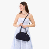 Velvet Blue Small | Model holding a half circle crossbody bag with handles and removable crossbody strap