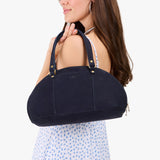 Velvet Blue Small | Model holding a half circle crossbody bag with handles and removable crossbody strap