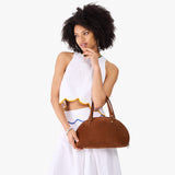 Wildwood Small | Model holding a half circle crossbody bag with handles and removable crossbody strap