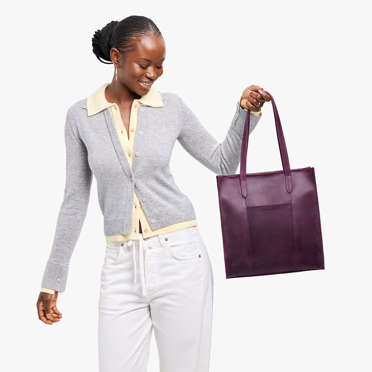 Larkspur*North/South | Model holding structured large tote bag with overlapping panels and crossbody strap