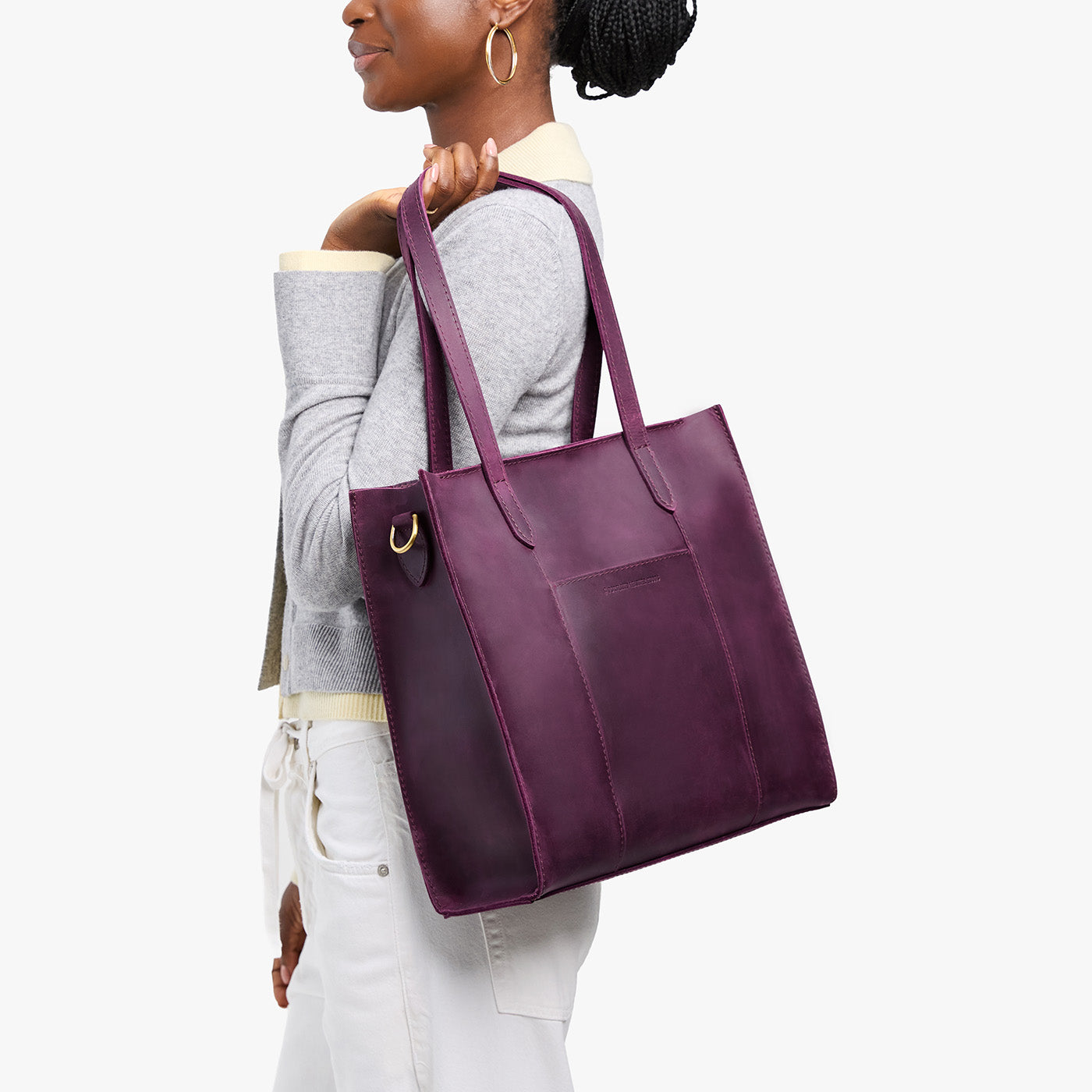Larkspur*North/South | Model holding structured large tote bag with overlapping panels and crossbody strap