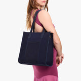 Velvet Blue North/South | Model holding structured large tote bag with overlapping panels and crossbody strap