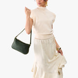 Evergreen Small | Model carrying petite bean shaped shoulder bag with a zipper closure