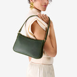 Evergreen Small | Model carrying petite bean shaped shoulder bag with a zipper closure