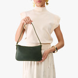 Evergreen Small | Model carrying petite bean shaped shoulder bag with a zipper closure