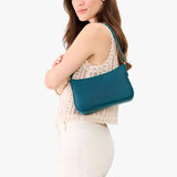Westward Blue Small | Model carrying petite bean shaped shoulder bag with a zipper closure