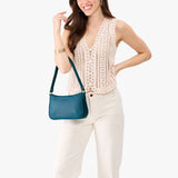 Westward Blue Small | Model carrying petite bean shaped shoulder bag with a zipper closure