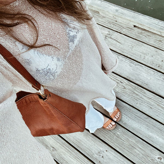 A person wearing a Triangle Shoulder Bag in Nutmeg