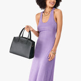 Black Medium | Model carrying leather tote bag with handles, adjustable crossbody strap, and two back pockets