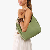 Laurel Medium | Model holding u-shaped, flat-bottomed leather shoulder bag with adjustable strap