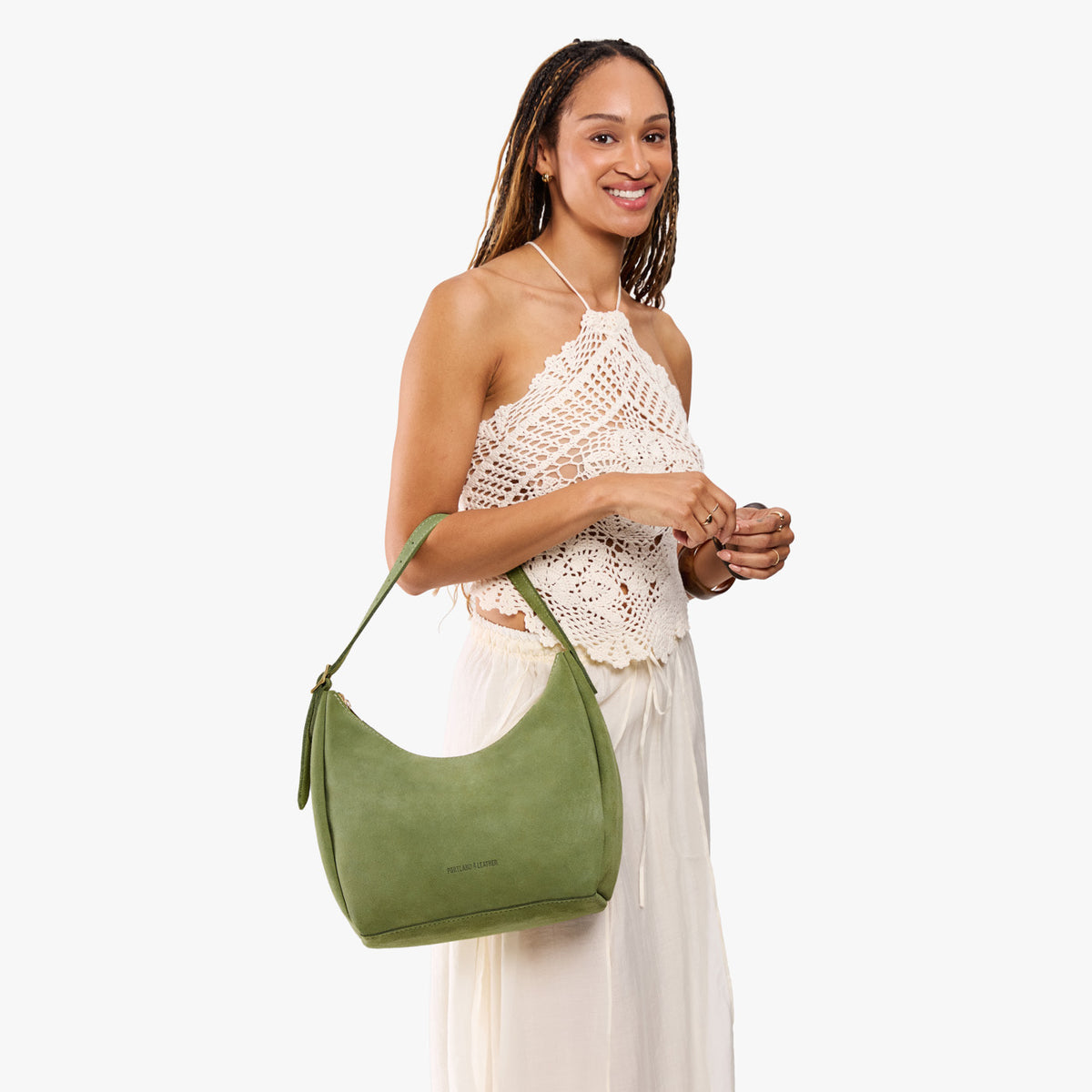Laurel*Medium | Model holding u-shaped, flat-bottomed leather shoulder bag with adjustable strap