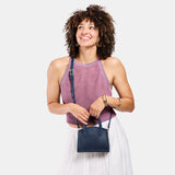 Deep Water Mini | Model carrying small leather tote bag with handles, adjustable crossbody strap, and one back pocket