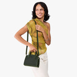 Evergreen Mini | Model carrying small leather tote bag with handles, adjustable crossbody strap, and one back pocket