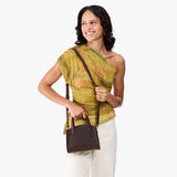 Moose Mini | Model carrying small leather tote bag with handles, adjustable crossbody strap, and one back pocket