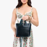 Boreal Classic | Model holding crossbody tote bag with snap closure and front pocket
