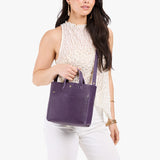 Empire Classic | Model holding crossbody tote bag with snap closure and front pocket