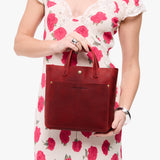 Phoenix Classic | Model holding crossbody tote bag with snap closure and front pocket