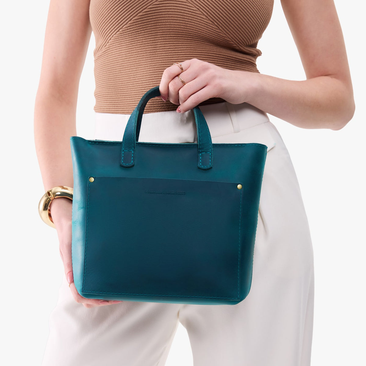 Westward Blue*Zipper | Model holding crossbody tote bag with zipper closure and front pocket