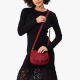 Chili Red Small | Model wearing a petite leather Crossbody with a flap and magnetic closure