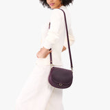 Larkspur Small | Model wearing a petite leather Crossbody with a flap and magnetic closure