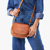 Sienna Small | Model wearing a petite leather Crossbody with a flap and magnetic closure
