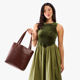 Cognac Medium Classic | Model wearing leather tote bag with riveted straps and exterior key loop