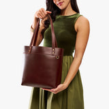 Cognac Medium Classic | Model wearing leather tote bag with riveted straps and exterior key loop