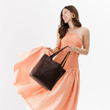 Coldbrew Medium Classic | Model holding leather tote bag with riveted straps and exterior key loop