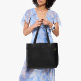 Pebbled--black Large Classic | Model wearing leather tote bag with riveted straps and exterior key loop
