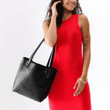 Pebbled--black Medium Classic | Model wearing leather tote bag with riveted straps and exterior key loop