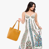 Sunshine Medium Classic| Model wearing leather tote bag with riveted straps and exterior key loop