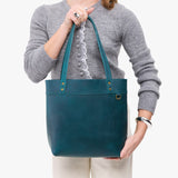 Westward Blue Medium Classic | Model wearing leather tote bag with riveted straps and exterior key loop