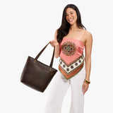 Coldbrew Medium Zipper | Model wearing leather tote bag with riveted straps and exterior key loop