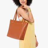 Honey Medium Zipper | Model wearing leather tote bag with riveted straps and exterior key loop