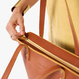 Honey Medium Zipper | Model wearing leather tote bag with riveted straps and exterior key loop