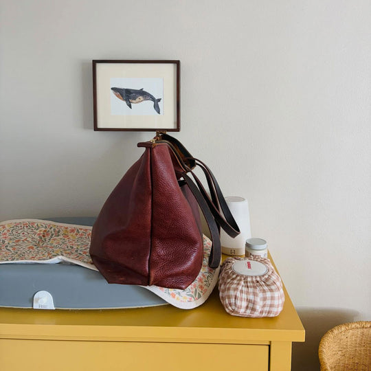 A Zipper Leather Tote Bag resting on a changing table.