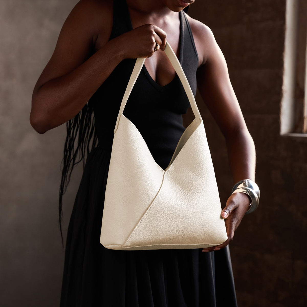 Pebbled Bone*Large | Model holding mid-size shoulder bag with magnetic snap closure