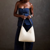 Pebbled Bone Oversized | Model holding a large shoulder bag with magnetic snap closure