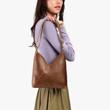 Asheville Small | Model wearing petite shoulder bag with adjustable strap and magnetic snap closure