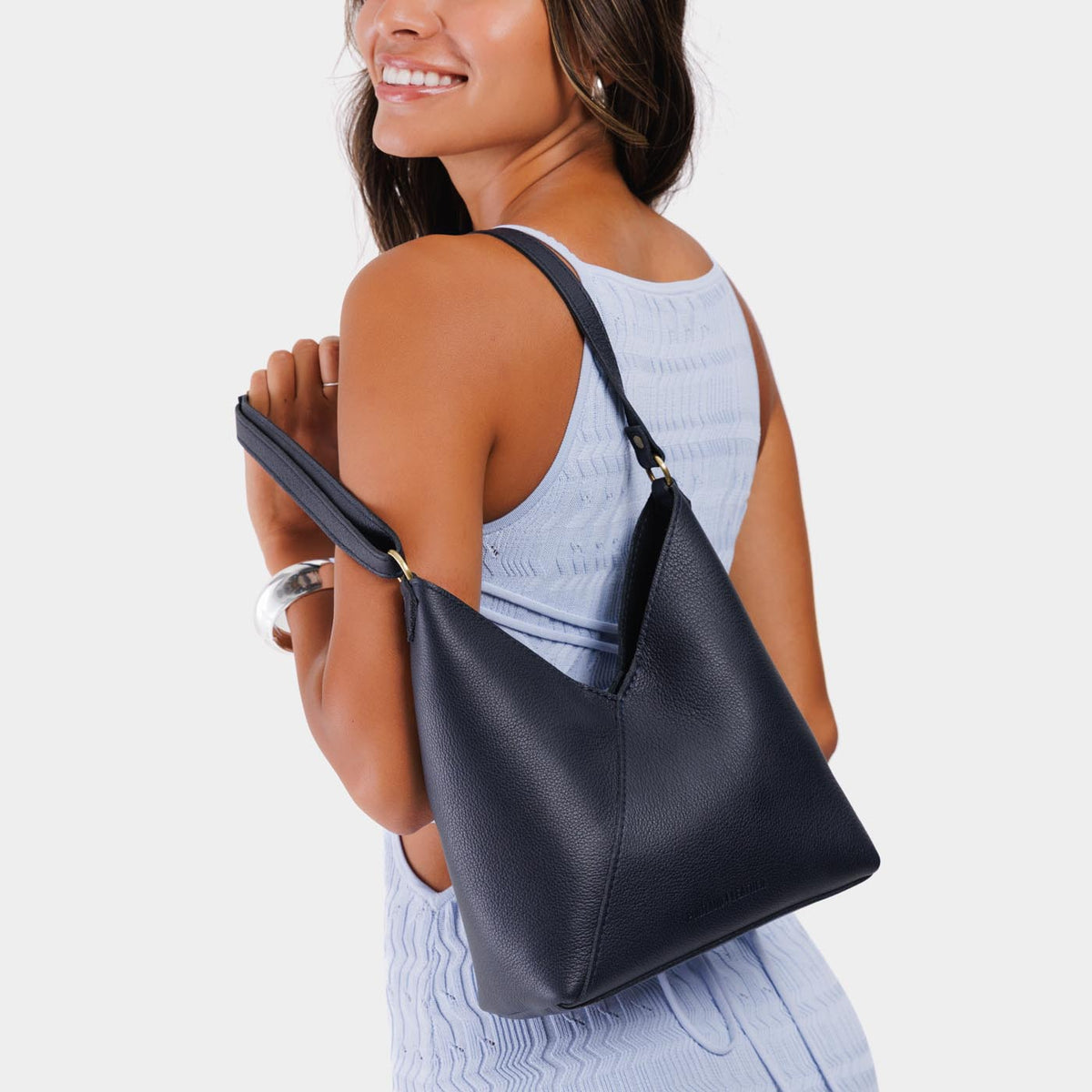 Night Owl*Small | Model wearing petite shoulder bag with adjustable strap and magnetic snap closure