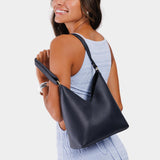 Night Owl Small | Model wearing petite shoulder bag with adjustable strap and magnetic snap closure