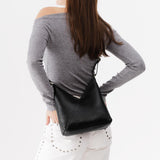 Pebbled--black Small | Model wearing petite shoulder bag with adjustable strap and magnetic snap closure