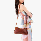 Nutmeg Small | Model wearing a leather Crossbody with a flap and magnetic closure