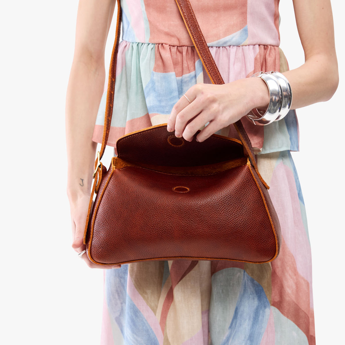 Nutmeg*Small | Model wearing a leather Crossbody with a flap and magnetic closure