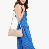 Oatmilk Small | Model wearing a leather Crossbody with a flap and magnetic closure