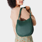 Forest Green Medium | Woman wearing rounded shoulder bag with adjustable strap on a white background