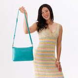 Seafoam Large | Model holding a zip top crossbody bag with detachable strap