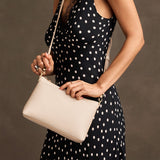 Pebbled Bone Small | Model wearing a zip top petite crossbody bag with detachable strap