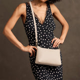 Pebbled Bone Small | Model wearing a zip top petite crossbody bag with detachable strap